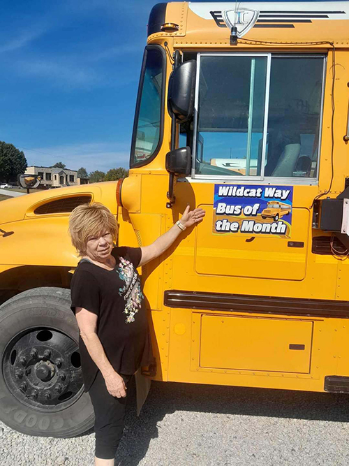 Mrs. Shirley posing in front of school bus