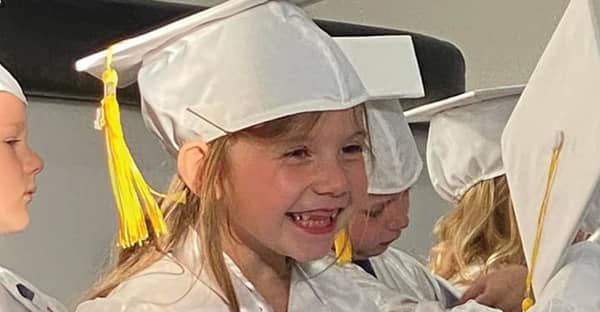 small girl in graduation cap and gown